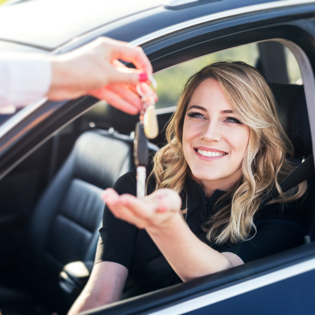 Mujer feliz recibiendo las llaves de un coche alquilado en Gran Canaria